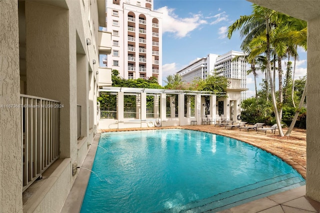 view of swimming pool with pool water feature, a patio, and a pergola