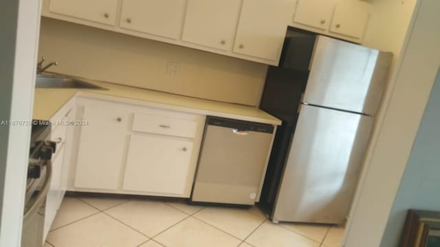 kitchen with white cabinetry, stainless steel appliances, sink, and light tile patterned floors