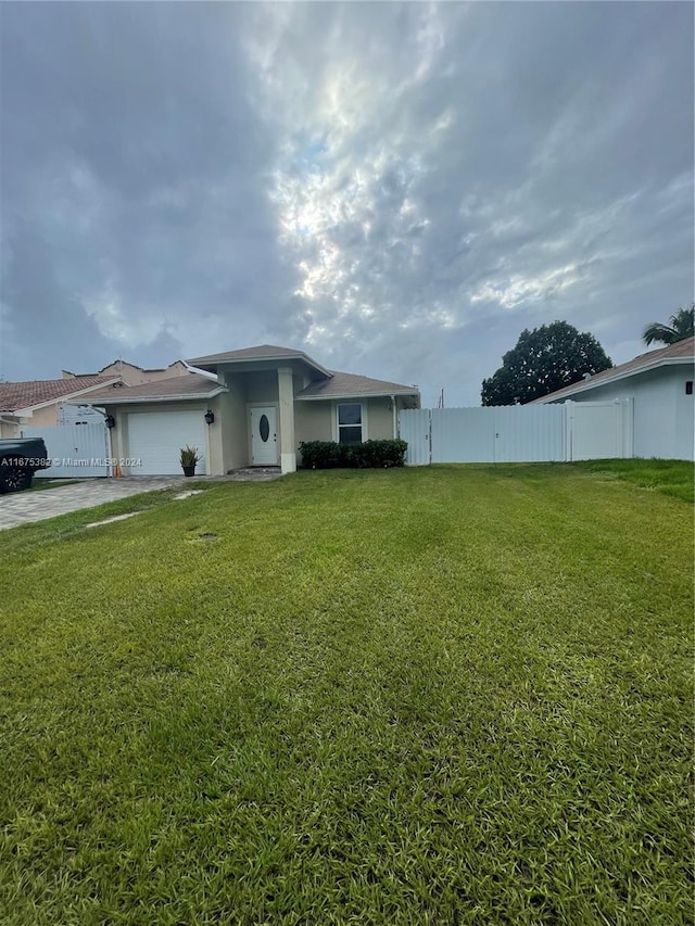 1369 Rainbow Ave, Palm Beach, FL 33406 - view of front facade featuring an attached garage, concrete driveway, and stucco siding