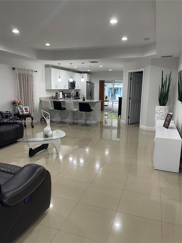 1369 Rainbow Ave, Palm Beach, FL 33406 - living room featuring light tile patterned flooring, a tray ceiling, and recessed lighting