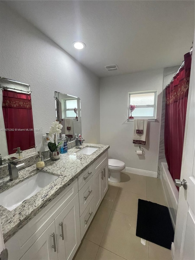 full bathroom with toilet, vanity, tile patterned floors, and shower / tub combo