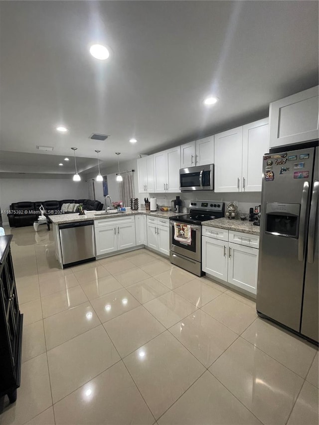 1369 Rainbow Ave, Palm Beach, FL 33406 - kitchen with appliances with stainless steel finishes, white cabinets, recessed lighting, open floor plan, and light tile patterned floors