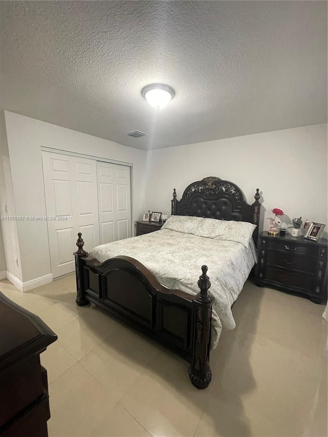 1369 Rainbow Ave, Palm Beach, FL 33406 - bedroom with a closet, a textured ceiling, and light tile patterned floors
