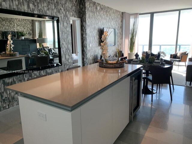 kitchen featuring wine cooler and white cabinetry