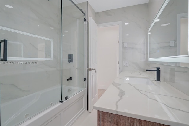 bathroom featuring vanity and combined bath / shower with glass door