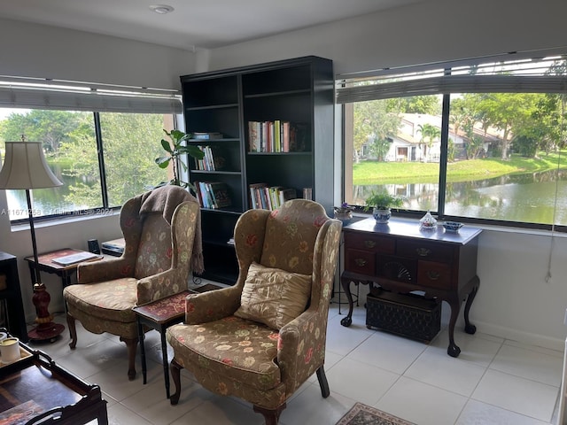 living area with light tile patterned flooring and a water view