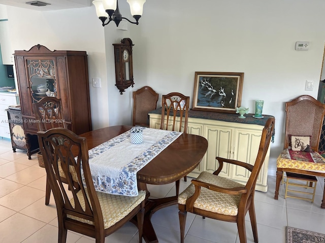 tiled dining room featuring a chandelier