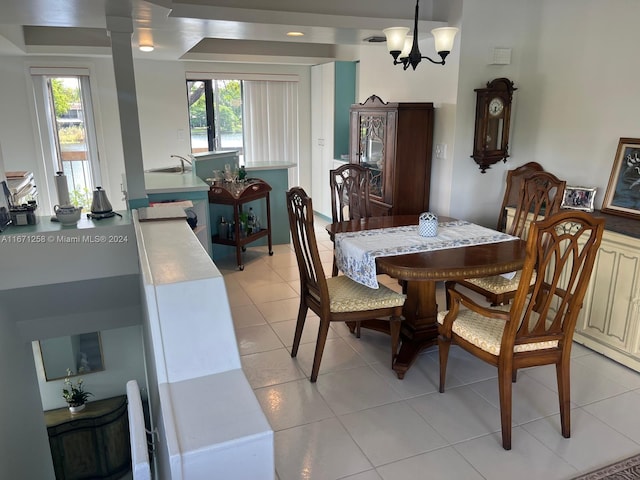 tiled dining space with sink, a notable chandelier, and a wealth of natural light