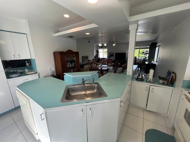 kitchen with a kitchen island with sink, ornate columns, sink, light tile patterned floors, and white cabinets