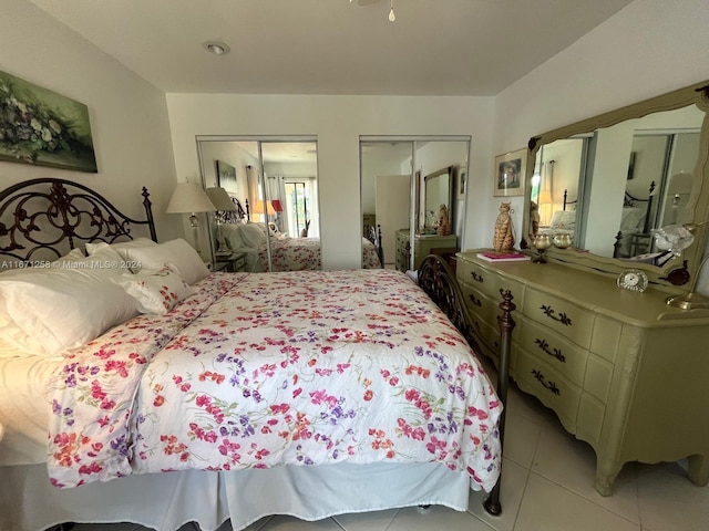 tiled bedroom featuring multiple closets