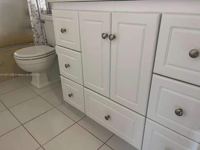 bathroom with toilet, tile patterned floors, and curtained shower