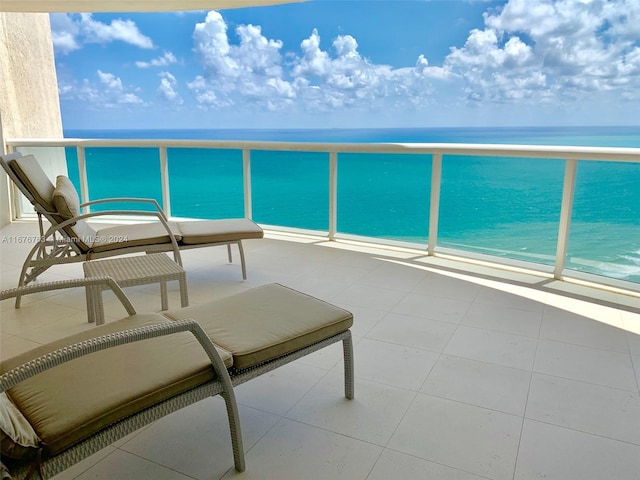 balcony with a water view and a view of the beach