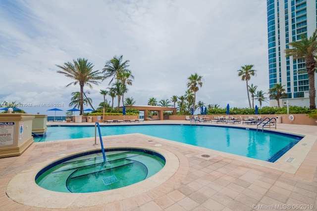 view of swimming pool featuring a community hot tub and a patio