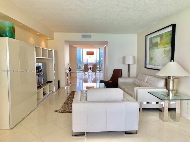 living room with a textured ceiling and light tile patterned flooring