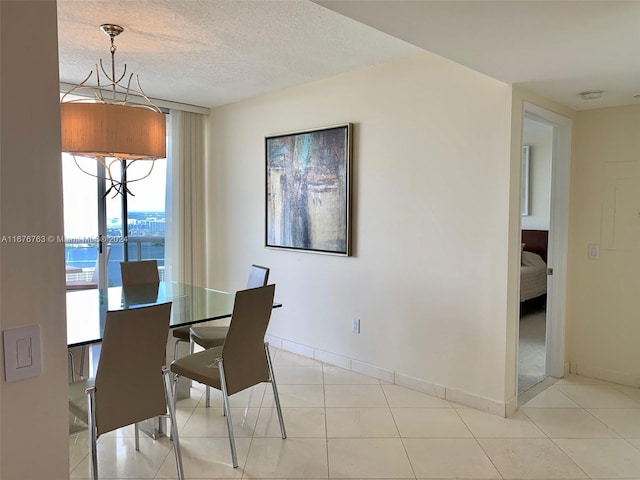 tiled dining area featuring a water view and a textured ceiling