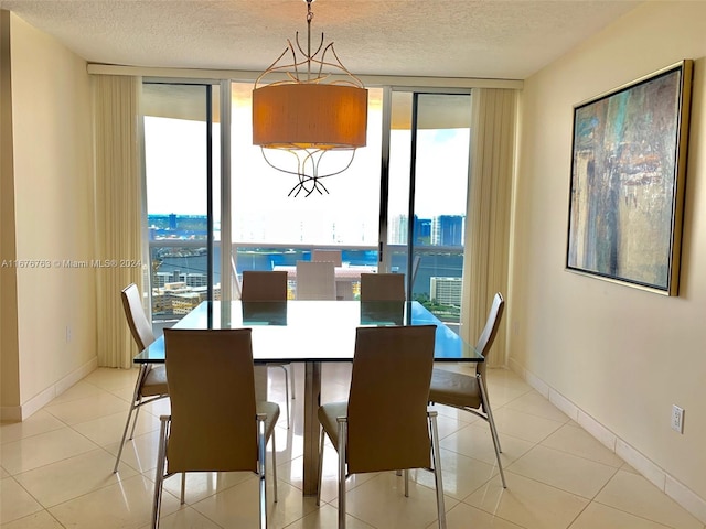 dining space with a textured ceiling, a wealth of natural light, and floor to ceiling windows