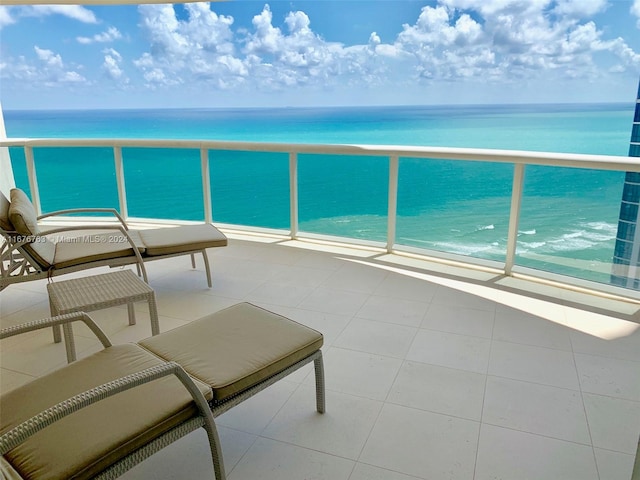 balcony featuring a water view and a beach view