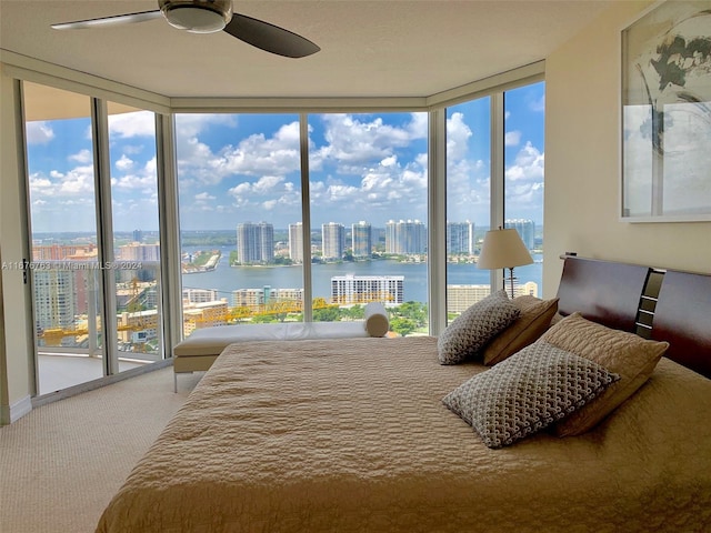 bedroom featuring multiple windows, a water view, and ceiling fan