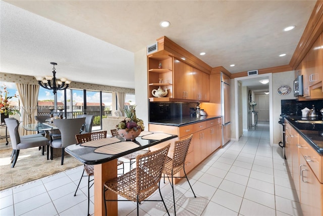 kitchen featuring stainless steel appliances, decorative light fixtures, decorative backsplash, light tile patterned floors, and a chandelier