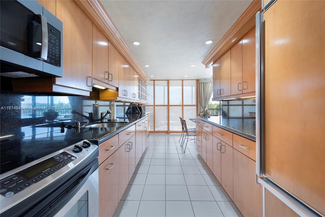 kitchen with light tile patterned floors, stainless steel appliances, sink, and light brown cabinets