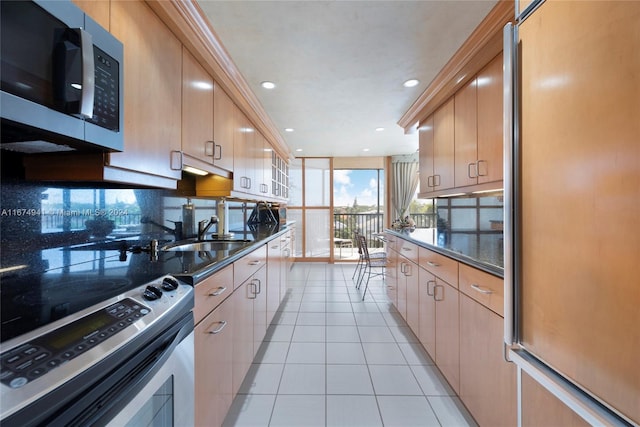 kitchen with sink, appliances with stainless steel finishes, light tile patterned flooring, and light brown cabinets