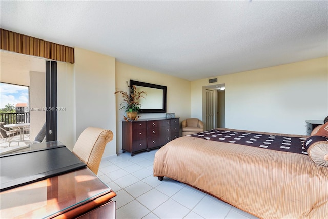 tiled bedroom with a textured ceiling and access to outside