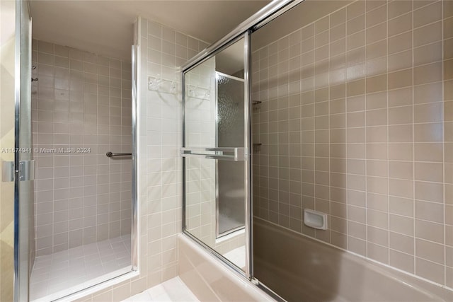 bathroom with bath / shower combo with glass door