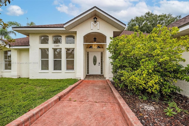 entrance to property featuring a lawn