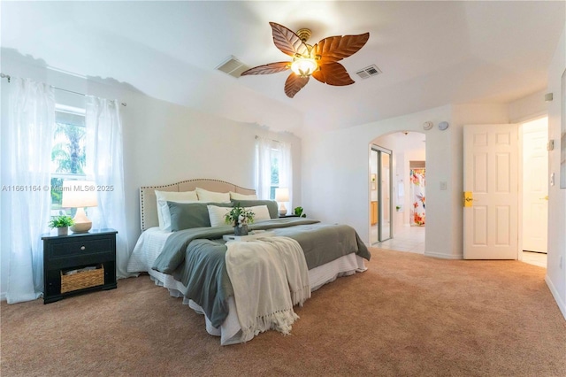 carpeted bedroom with multiple windows and ceiling fan