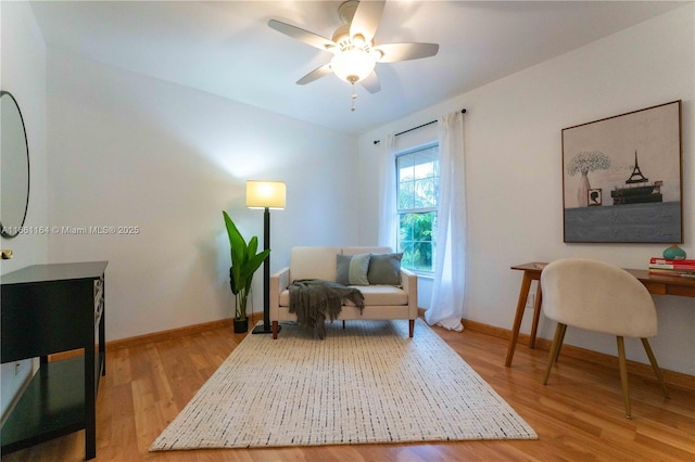 living area with hardwood / wood-style flooring and ceiling fan