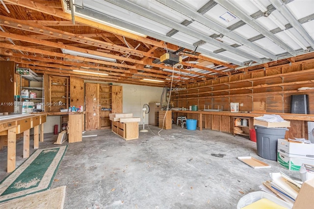 garage with a garage door opener and a workshop area