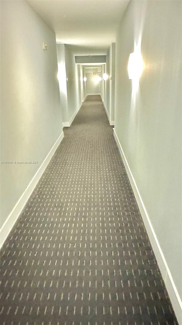 hallway with dark colored carpet