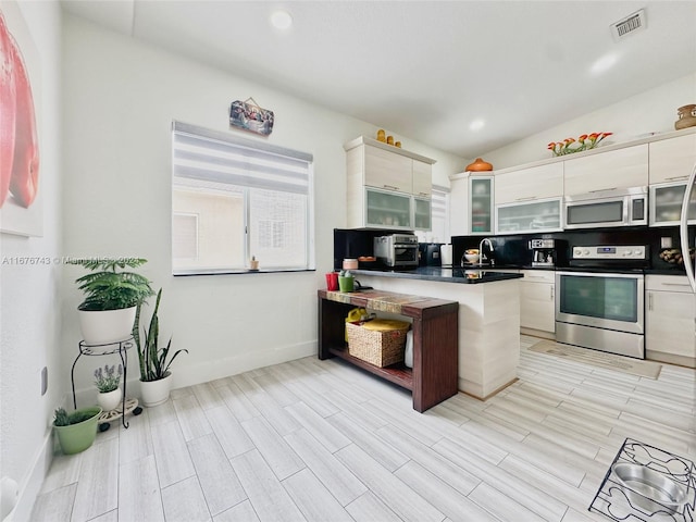 kitchen featuring appliances with stainless steel finishes, white cabinets, sink, and light hardwood / wood-style floors