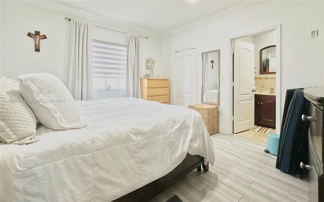 bedroom with crown molding, light hardwood / wood-style flooring, and ensuite bath