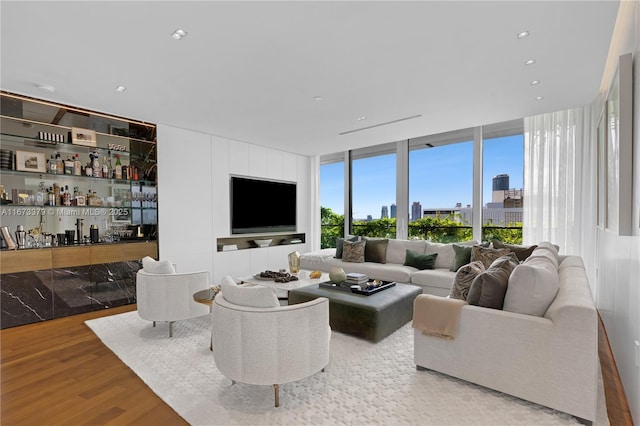 living area with recessed lighting, bar area, and wood finished floors