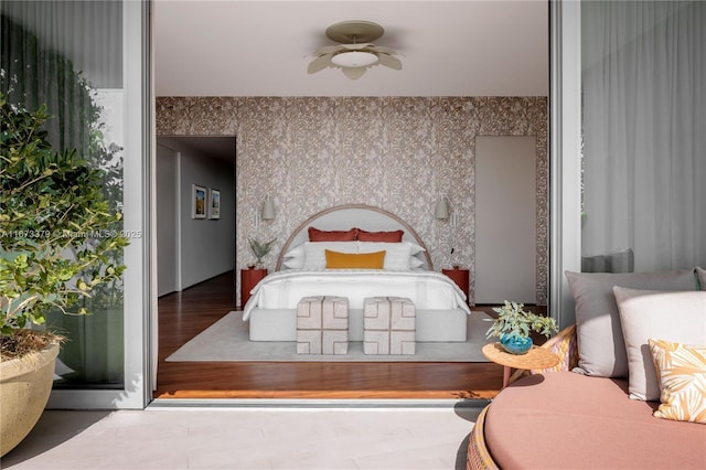 bedroom featuring wood finished floors and wallpapered walls