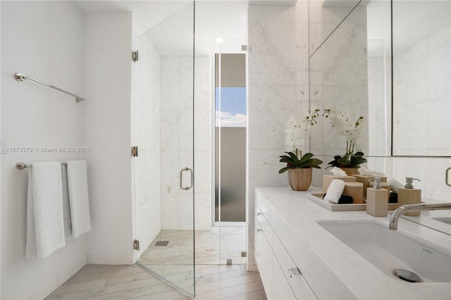 full bathroom featuring a stall shower, vanity, and tile walls