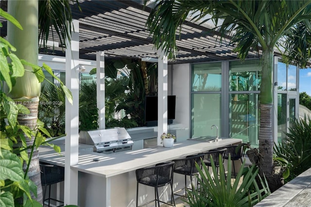 view of patio / terrace featuring a pergola, a grill, exterior bar, and an outdoor kitchen