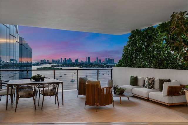 balcony at dusk with a view of city and outdoor lounge area