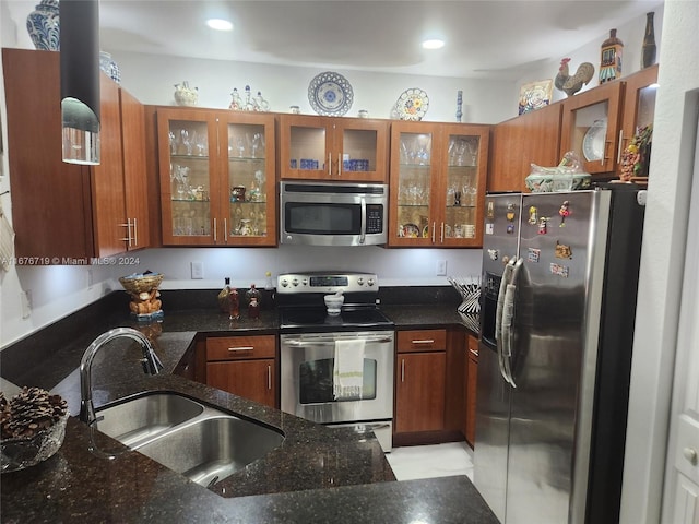 kitchen with dark stone countertops, sink, and appliances with stainless steel finishes