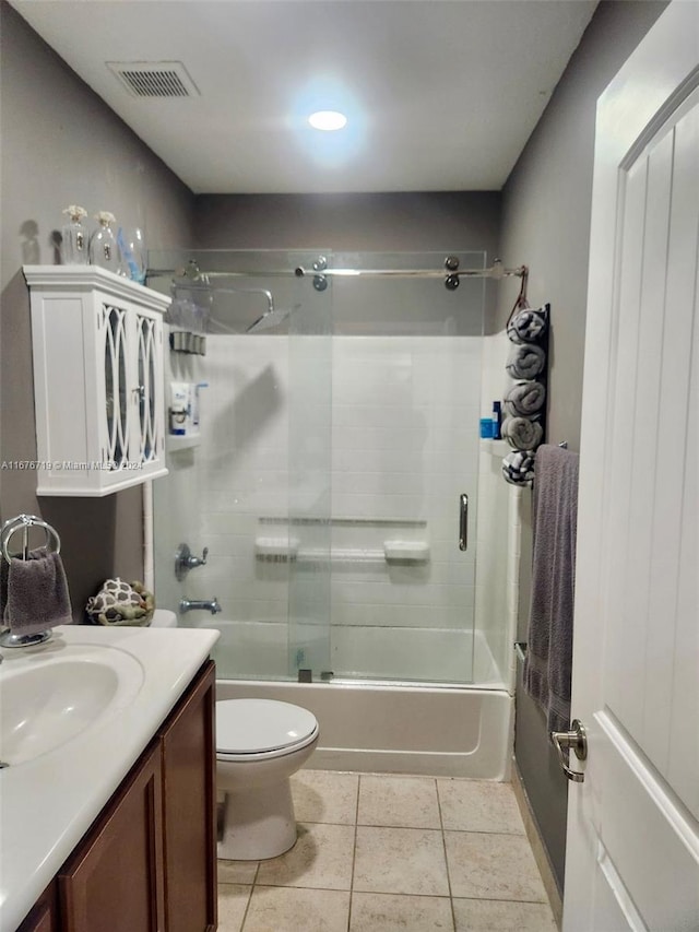 full bathroom with tile patterned floors, vanity, enclosed tub / shower combo, and toilet