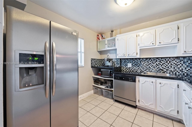 kitchen featuring decorative backsplash, white cabinets, and stainless steel appliances