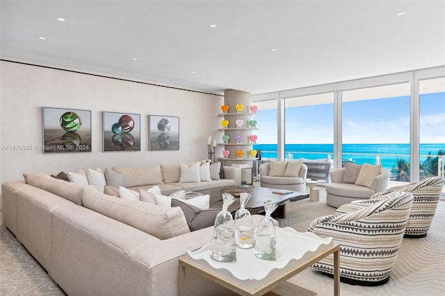 living room featuring light carpet, a water view, and floor to ceiling windows