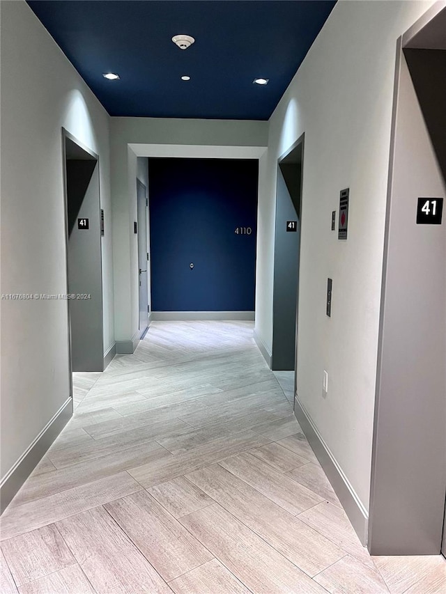 hallway with light hardwood / wood-style flooring