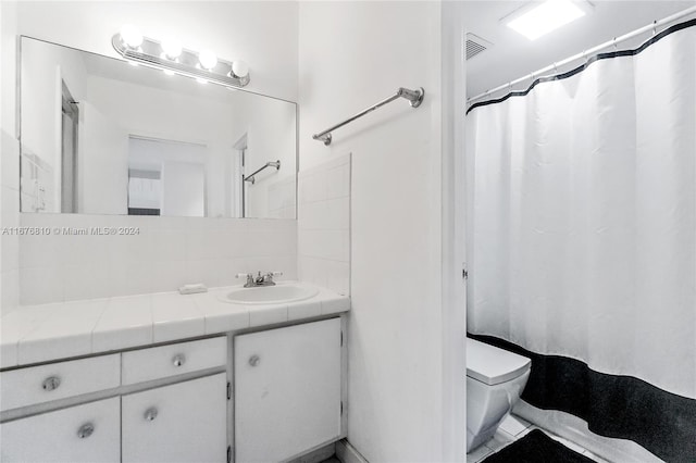 bathroom with vanity, curtained shower, and toilet