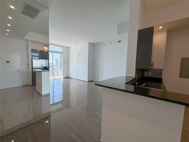 325 S Biscayne Blvd Unit 19, Miami, FL 33131 - kitchen with stainless steel built in refrigerator, a peninsula, decorative backsplash, dark countertops, and recessed lighting