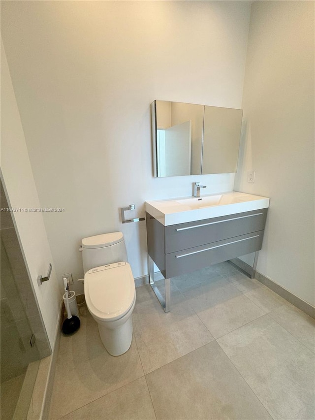 bathroom featuring vanity, toilet, tile patterned floors, and walk in shower