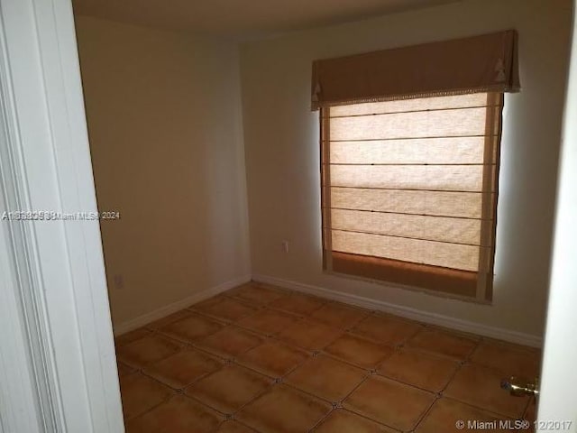 unfurnished room featuring dark tile patterned flooring