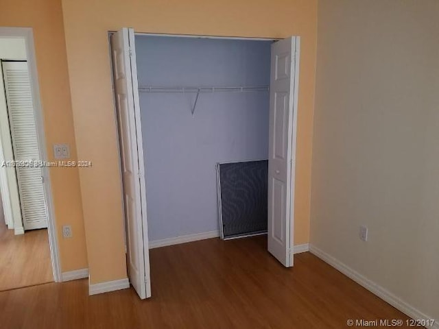 unfurnished bedroom featuring hardwood / wood-style flooring and a closet