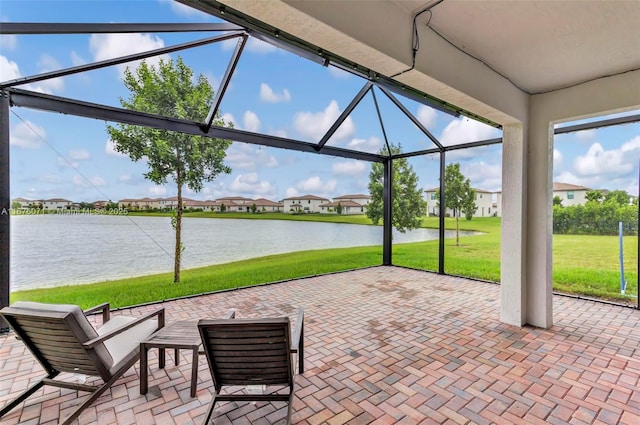 view of patio featuring a water view and a lanai